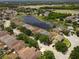 Aerial view of houses and a lake in a residential community at 17539 Balmaha Dr, Land O Lakes, FL 34638