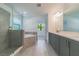 Modern bathroom with soaking tub, walk-in shower, and grey tile at 7203 S De Soto St, Tampa, FL 33616