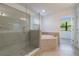 Elegant bathroom featuring a soaking tub, walk-in shower, and dual vanity at 7203 S De Soto St, Tampa, FL 33616