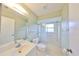 Clean and bright bathroom featuring a shower over tub with a glass door and white fixtures at 2620 Locksley St # 261, Sun City Center, FL 33573