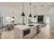 Modern kitchen with a large center island, pendant lighting, stainless steel appliances, and an open view to the living area at 325 33Rd N Ave, St Petersburg, FL 33704