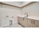 Modern laundry room with quartz countertops, built-in cabinets, and a utility sink at 325 33Rd N Ave, St Petersburg, FL 33704
