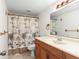 Clean bathroom with wood vanity, shower/tub combo and palm-tree shower curtain at 776 100Th N Ave # 104, St Petersburg, FL 33702
