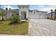 Two-story home with gray brick facade, two-car garage and landscaped yard at 17729 Roost Pl, Bradenton, FL 34211