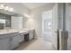 Modern bathroom with double vanity and view of a bedroom at 17729 Roost Pl, Bradenton, FL 34211