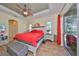 Main bedroom with red bedding, wood floors, and access to the backyard at 804 Regal Manor Way, Sun City Center, FL 33573