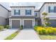 Two-story townhome with attached garage and manicured landscaping at 8065 Rolling Shell Trl, Wesley Chapel, FL 33545