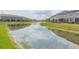 Peaceful waterfront view of a canal with homes reflecting in the water at 8065 Rolling Shell Trl, Wesley Chapel, FL 33545