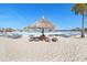 Beachfront lounge chairs and a thatched umbrella provide ample shade and relaxation at 8065 Rolling Shell Trl, Wesley Chapel, FL 33545