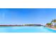 Expansive lagoon pool with clear blue water and beach access at 8065 Rolling Shell Trl, Wesley Chapel, FL 33545