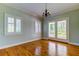 Well-lit bedroom featuring wood floors, white trim, windows, and French doors at 7510 N Mobley Rd, Odessa, FL 33556