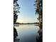 Scenic lake view with calm waters reflecting the sky, framed by trees at 7510 N Mobley Rd, Odessa, FL 33556
