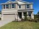 Two-story house with a neutral color palette, shutters, and a two-car garage at 18025 Tavernside Trl, Bradenton, FL 34211