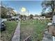 Vacant lot with overgrown vegetation and distant homes at 6902 Rhode Island Dr, Tampa, FL 33619