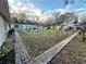 Large backyard with a paved pathway and mature trees at 6902 Rhode Island Dr, Tampa, FL 33619