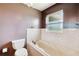 Bathroom with bathtub, toilet, and a window at 31226 Saint Joe Rd, Dade City, FL 33525
