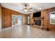 Living room with wood-paneled walls, fireplace, and tile floors at 31226 Saint Joe Rd, Dade City, FL 33525