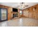 Living room with wood-paneled walls, fireplace, and tile floors at 31226 Saint Joe Rd, Dade City, FL 33525