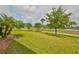 Landscaped backyard with lush lawn and mature trees at 1817 Pacific Dunes Dr, Sun City Center, FL 33573