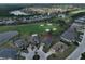 Aerial view of a house and community with golf course and lake at 404 Grand Chateaux Way, Sun City Center, FL 33573