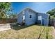 Backyard view showing a blue house, grass and a fence at 3005 Ybor St, Tampa, FL 33605