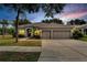 Two-story house with three-car garage at dusk at 12902 Cattail Shore Ln, Riverview, FL 33579