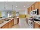 Kitchen features wood cabinets and tile floors at 12902 Cattail Shore Ln, Riverview, FL 33579