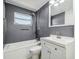 Gray bathroom with white fixtures, bathtub/shower combo, and window at 5910 Denver Ne St, St Petersburg, FL 33703