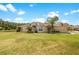 Single-story house with a landscaped lawn and palm trees, offering curb appeal at 30315 Lettingwell Cir, Wesley Chapel, FL 33543