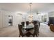 Dining area with glass-top table and dark chairs, open to living room at 30315 Lettingwell Cir, Wesley Chapel, FL 33543