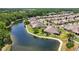 Aerial view of a community with houses surrounding a lake at 30315 Lettingwell Cir, Wesley Chapel, FL 33543