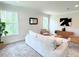 Bright living room with a light gray sofa, two armchairs, and large windows at 17476 Quentin Ave, Port Charlotte, FL 33954