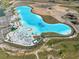Aerial view of a crystal-clear lagoon with beach and amenities at 9018 Rally Spring Loop, Wesley Chapel, FL 33545