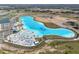 Aerial view of a crystal-clear lagoon with beach and amenities at 9018 Rally Spring Loop, Wesley Chapel, FL 33545