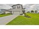 Two-story house with a two-car garage and a manicured lawn at 9018 Rally Spring Loop, Wesley Chapel, FL 33545