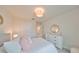 Well-lit bedroom with white bed and round mirror at 9018 Rally Spring Loop, Wesley Chapel, FL 33545