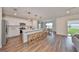 Modern kitchen with island, white cabinets, and hardwood floors at 9018 Rally Spring Loop, Wesley Chapel, FL 33545