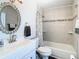 Bright bathroom featuring a decorative mirror, updated fixtures, and tiled shower with tub at 28330 Openfield Loop, Wesley Chapel, FL 33543