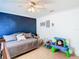 Inviting bedroom featuring stylish decor, a comfortable daybed, and vibrant blue accent wall at 28330 Openfield Loop, Wesley Chapel, FL 33543