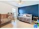 Lovely bedroom with a wood floor, daybed, crib, and a stylish accent wall at 28330 Openfield Loop, Wesley Chapel, FL 33543