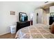 Comfortable bedroom featuring a patterned bedspread, dresser with TV and view to hallway at 28330 Openfield Loop, Wesley Chapel, FL 33543