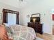Cozy bedroom featuring a patterned bedspread, dresser with a TV, and a large window at 28330 Openfield Loop, Wesley Chapel, FL 33543