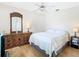 Bright bedroom with a ceiling fan, light wood floors, dresser, and mirror at 28330 Openfield Loop, Wesley Chapel, FL 33543