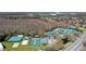 Aerial shot showcases a community center with tennis courts, sand volleyball, and swimming pools in a wooded area at 28330 Openfield Loop, Wesley Chapel, FL 33543