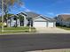 Charming single-story home featuring a three-car garage, manicured lawn, and beautiful landscaping at 28330 Openfield Loop, Wesley Chapel, FL 33543