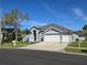Charming single Gathering home with a three-car garage and a well-manicured lawn on a sunny day at 28330 Openfield Loop, Wesley Chapel, FL 33543