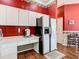 Kitchen area with built-in desk and adjacent white refrigerator for a functional culinary space at 28330 Openfield Loop, Wesley Chapel, FL 33543
