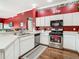Kitchen with stainless steel appliances, white cabinets, and a sink with a window view to the dining area at 28330 Openfield Loop, Wesley Chapel, FL 33543
