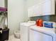 Bright laundry room with white cabinets and modern washer and dryer, offering ample storage at 28330 Openfield Loop, Wesley Chapel, FL 33543