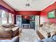 Spacious living room with dark red walls, hardwood floors, and comfortable sofas at 28330 Openfield Loop, Wesley Chapel, FL 33543